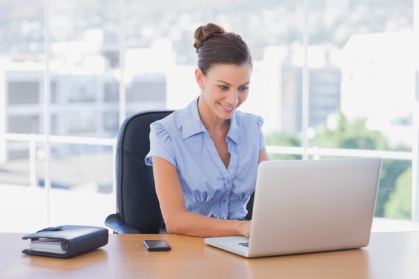 woman sitting at her desk working on her laptop