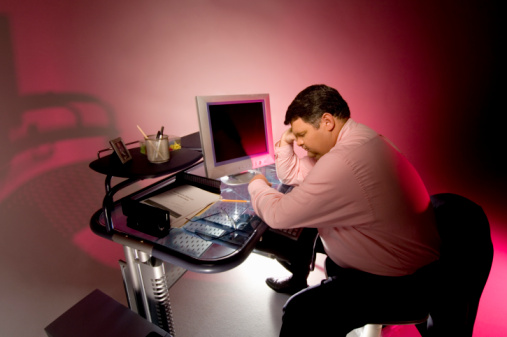 man sitting in front of a computer distraught 