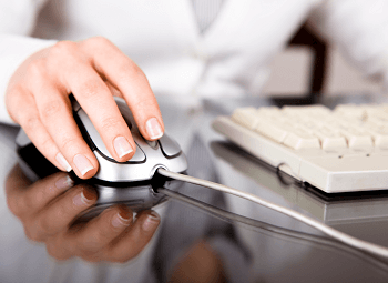 Hand on a computer mouse and keyboard
