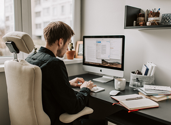 a person sitting at a desk in front of a computer